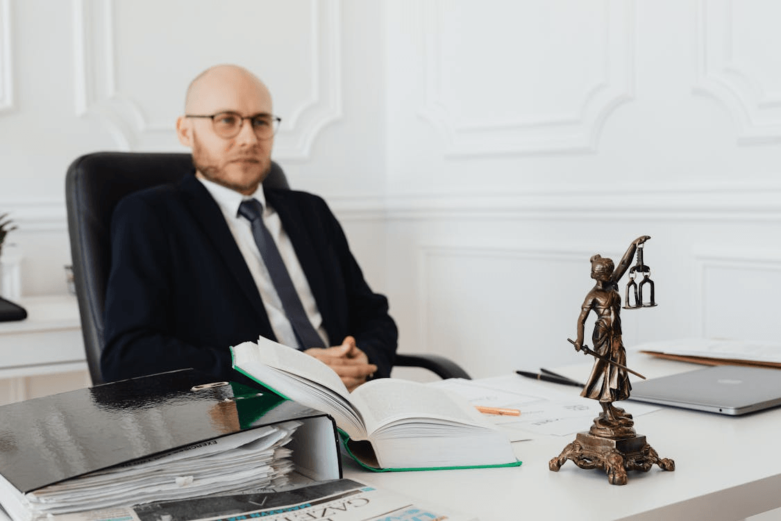 Civil rights attorney seated at desk with legal books and Lady Justice statue