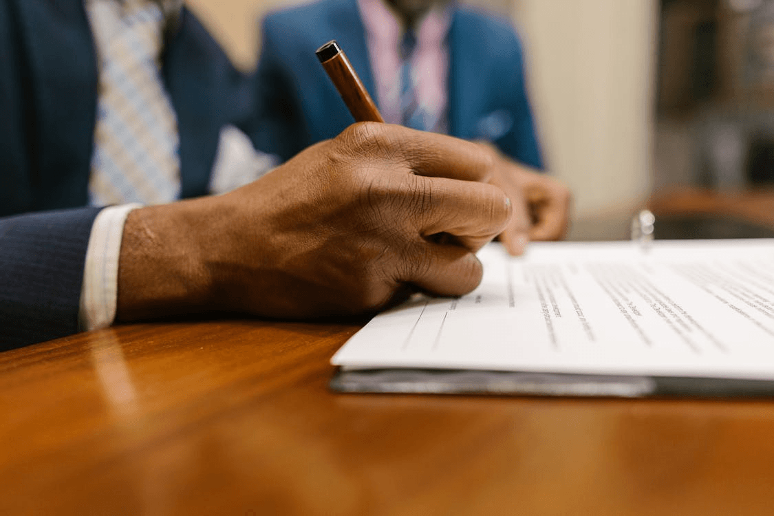 Person in suit signing legal documents to file a civil rights complaint